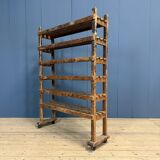 Old wooden workshop shelf with cast iron wheels.