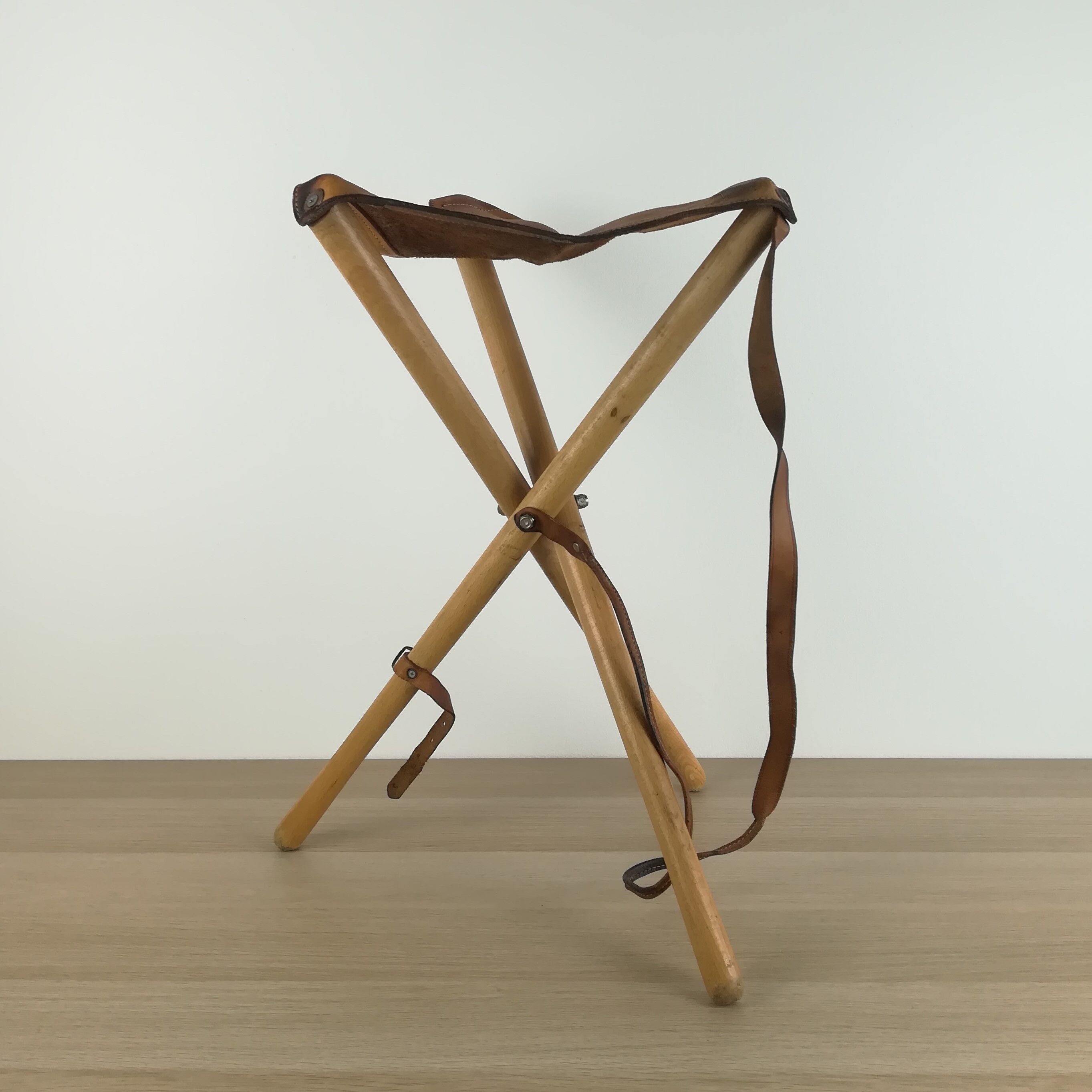 Foldable tripod stool in leather and wood
