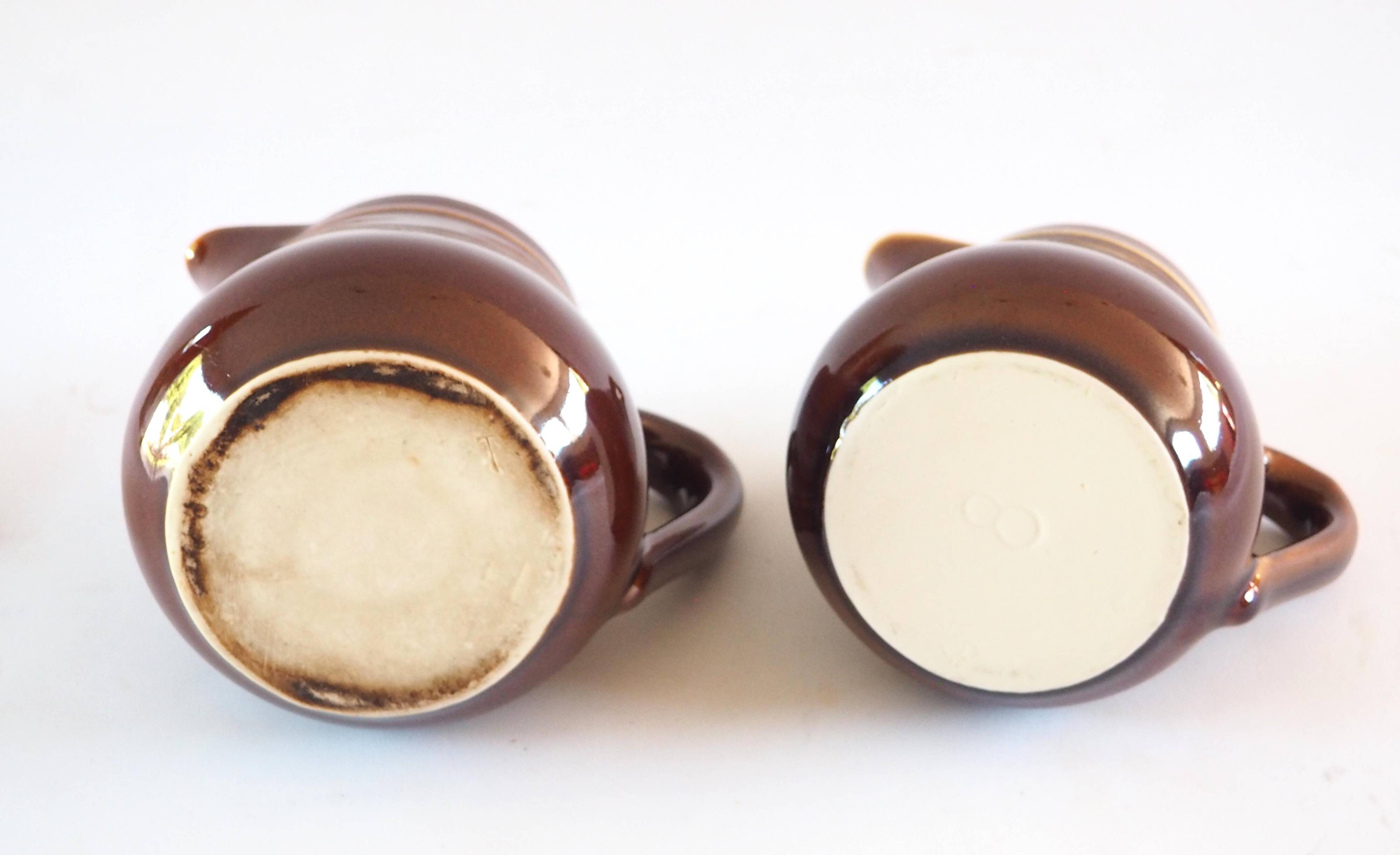 Duo of brown enamel pitchers