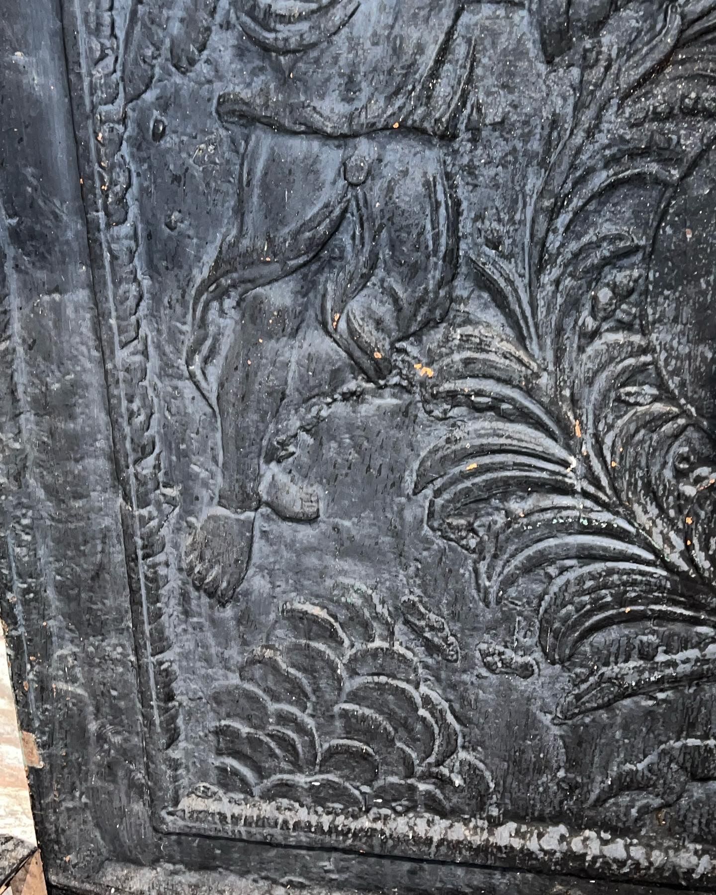 huge old fireplace plate has decoration of angels, crown and fleurs-de-lis