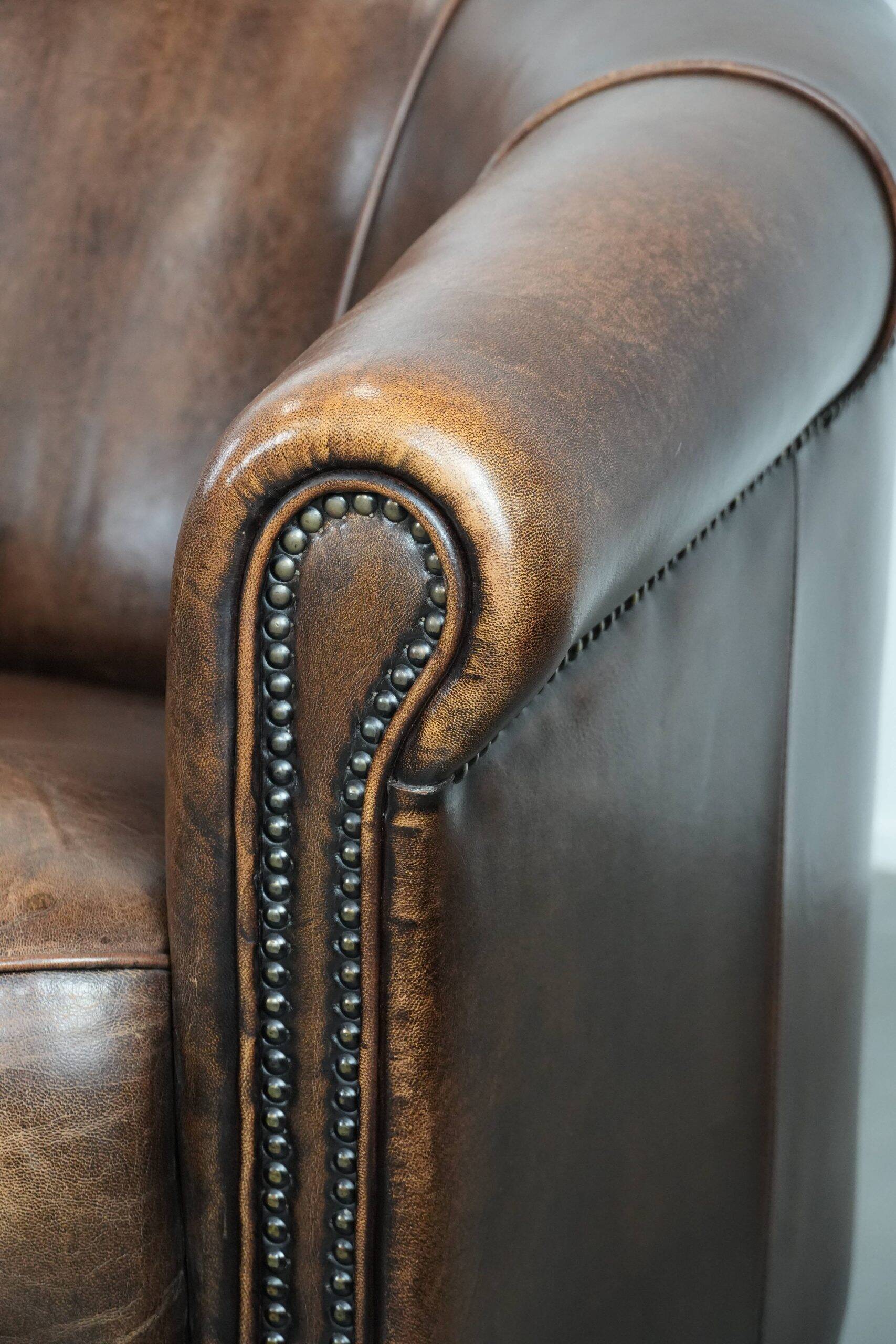 Set of two sheepskin club armchairs with fixed seat cushions