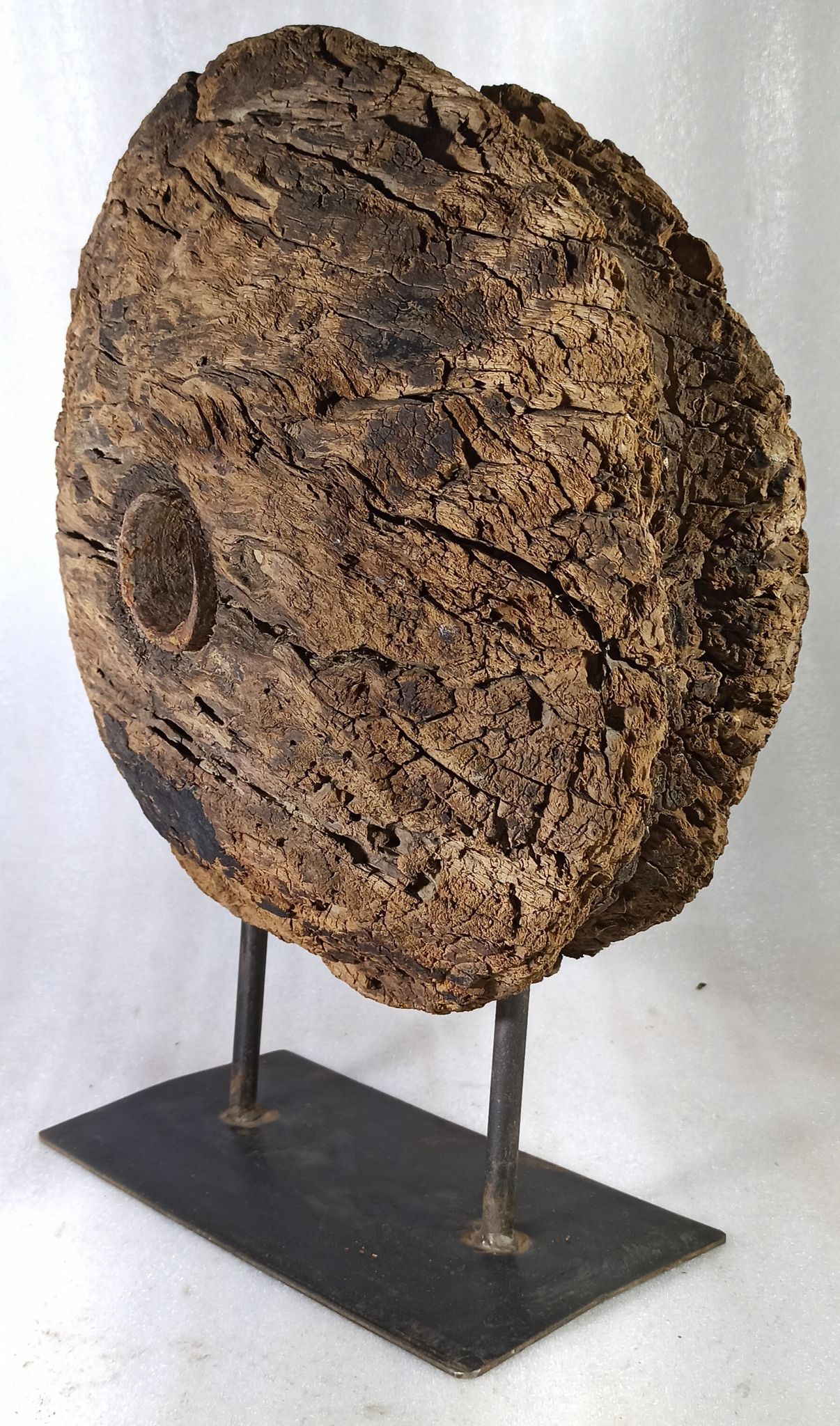 Old wooden pulley wheel on foot