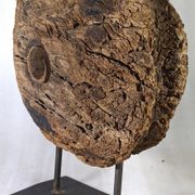 Old wooden pulley wheel on foot