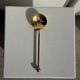 Small golden glass ice bucket with diamond point design and its scoop.