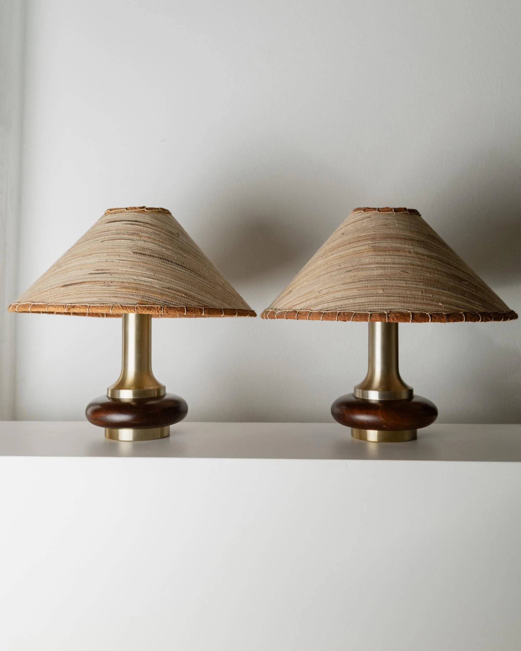 Lot of 2 vintage table lamps from the 1970s, dark wood oval bases with curved brass details, handmade natural fibre lampshades, elegant lighting.
