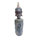 African statue of a woman, made of wood, brass, beads, and seashells.