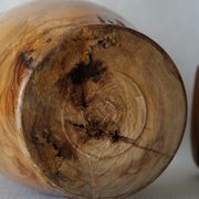 Artisanal turned olive wood vase with varnish.