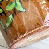Cache-pot en céramique marron avec motif de feuillage vert peint à la main.