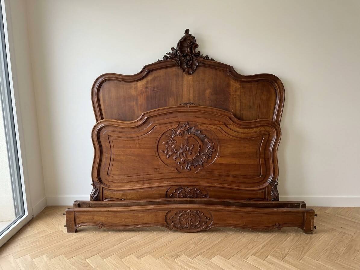 Antique carved bed in Louis XV style made of wood.