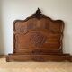 Antique carved bed in Louis XV style made of wood.