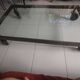 Industrial coffee table in solid metal with a glass top.