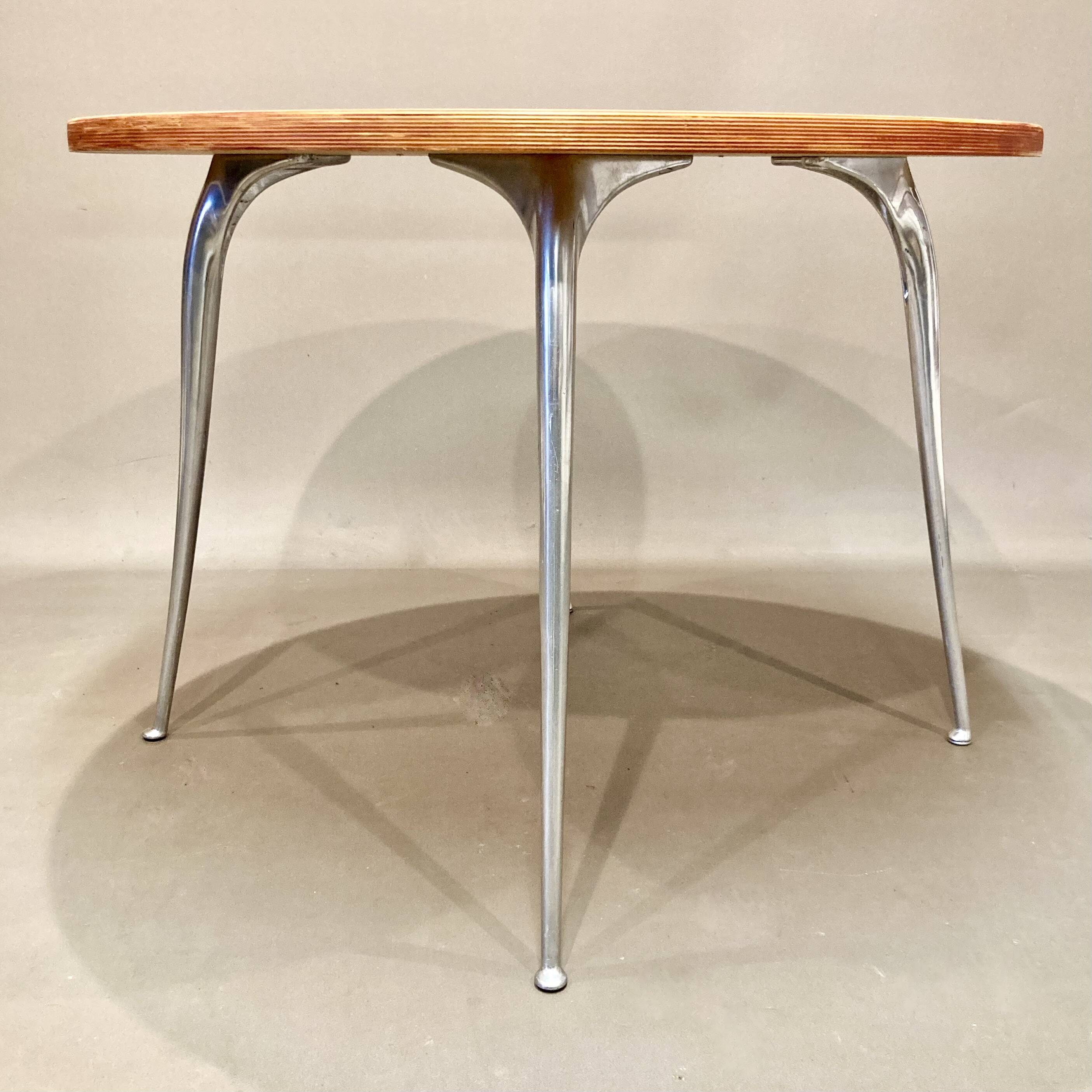 High table in solid raw wood and cast aluminum.