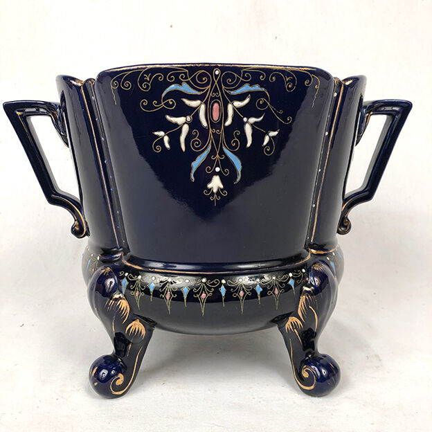 Large earthenware pot cover with enamelled decoration on a blue oven background