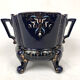 Large earthenware pot cover with enamelled decoration on a blue oven background