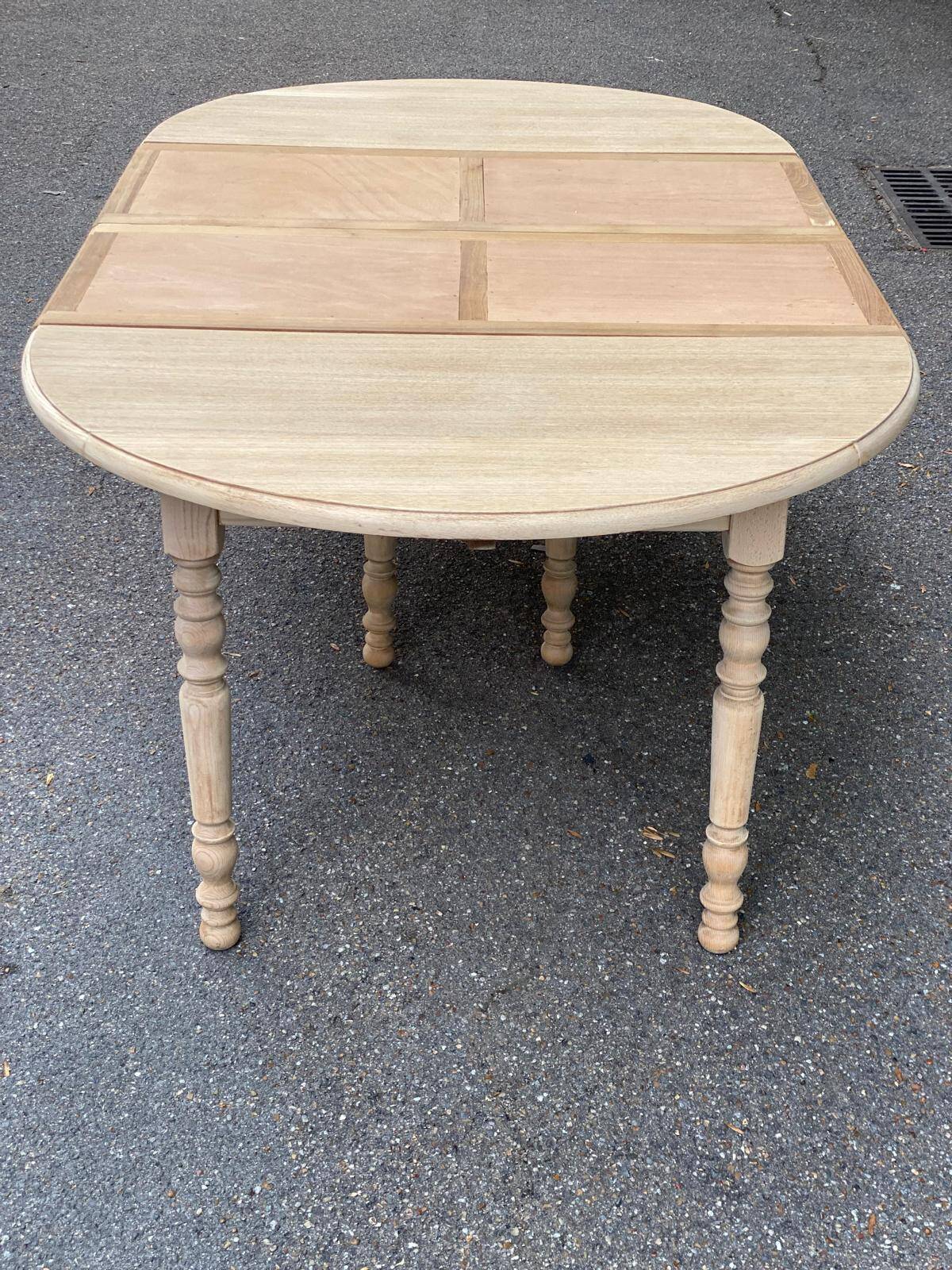 Round dining table with extendable leaves, Louis Philippe style, stripped in raw oak.