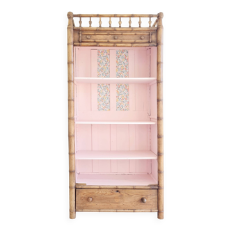 Library, old wooden cabinet imitating bamboo painted in pink