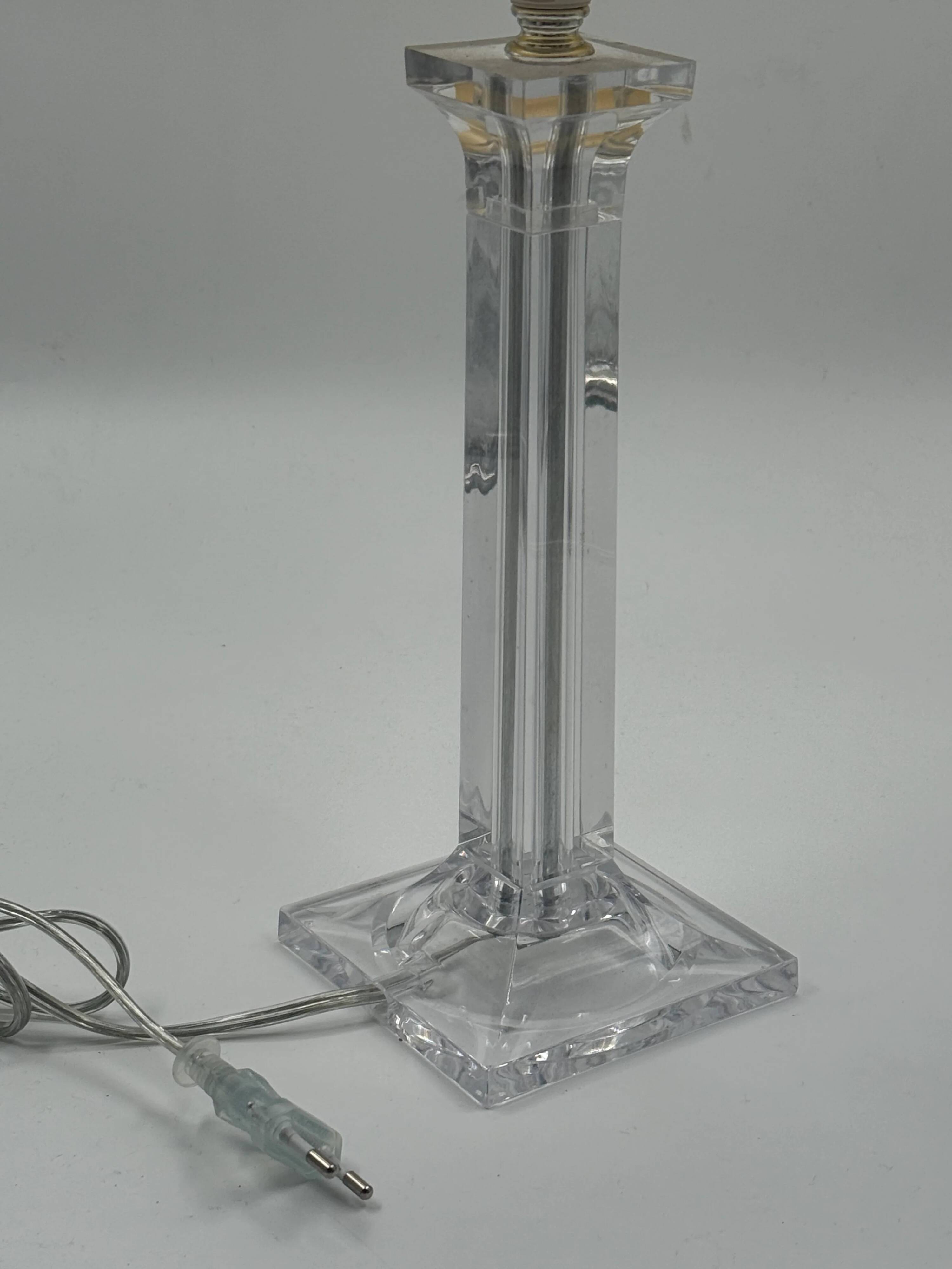 Modern table lamp in plexiglass with fabric shade.