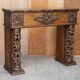 Antique fireplace from around 1880 in solid hand-carved elm with openwork columns.