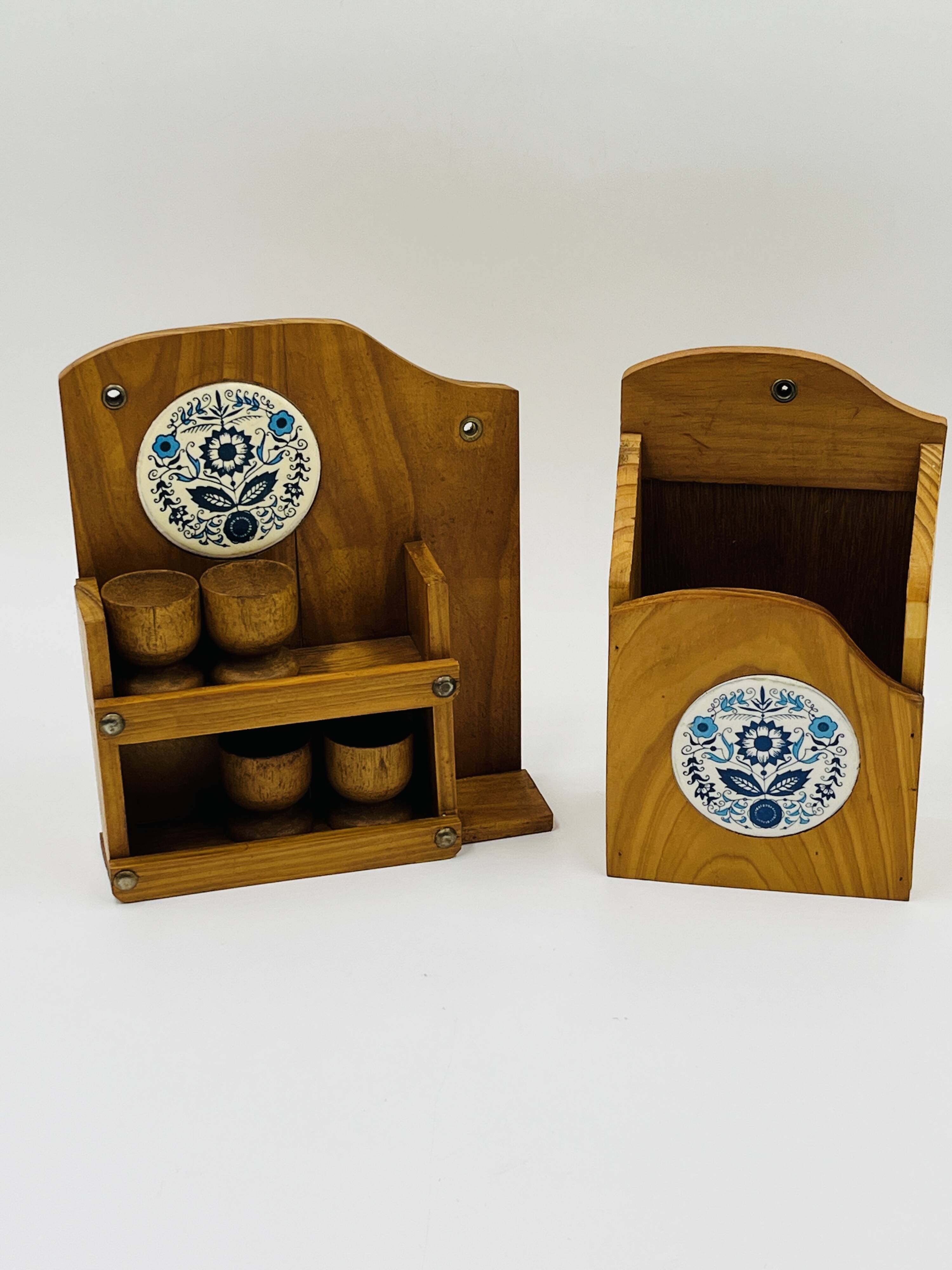 Wall-mounted egg cup holder and wooden utensil holder.