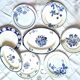 Mismatched antique flat plates accompanied by dishes.