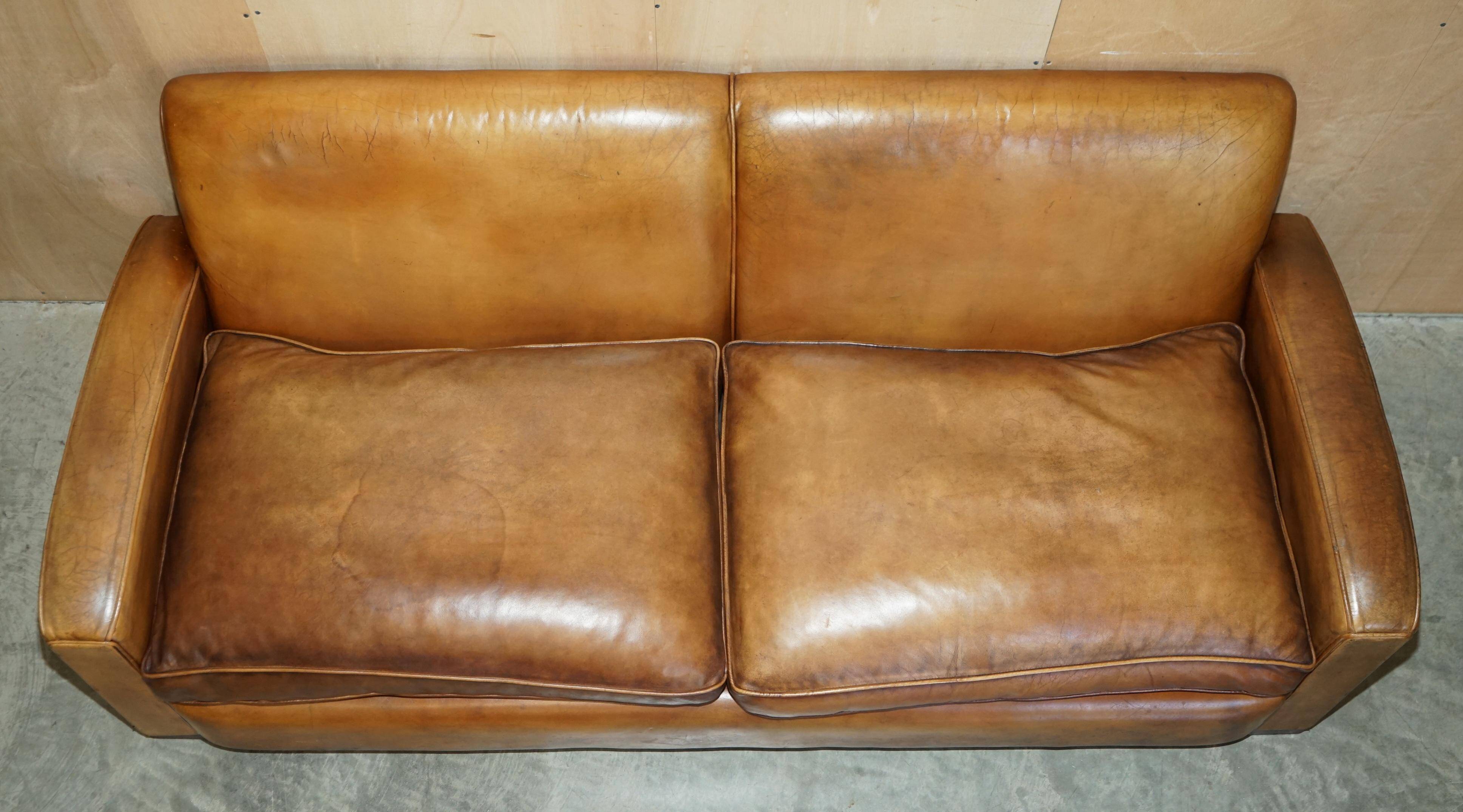 Three-seater Art Deco style leather sofa with feather cushions.