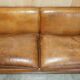 Three-seater Art Deco style leather sofa with feather cushions.