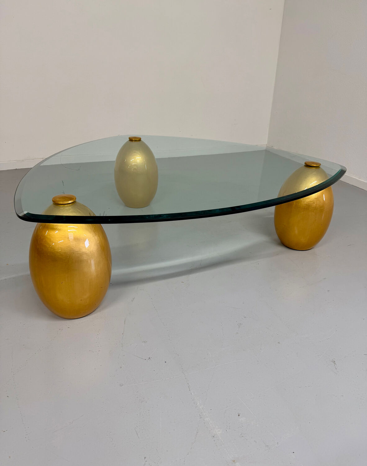 Vintage Italian design coffee table with a glass top and gold base, dating from the 1980s.