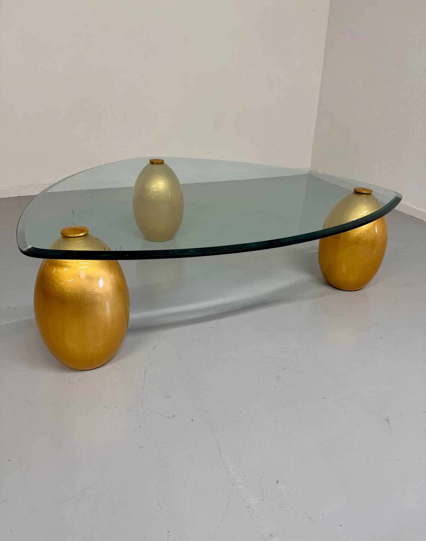 Vintage Italian design coffee table with a glass top and gold base, dating from the 1980s.