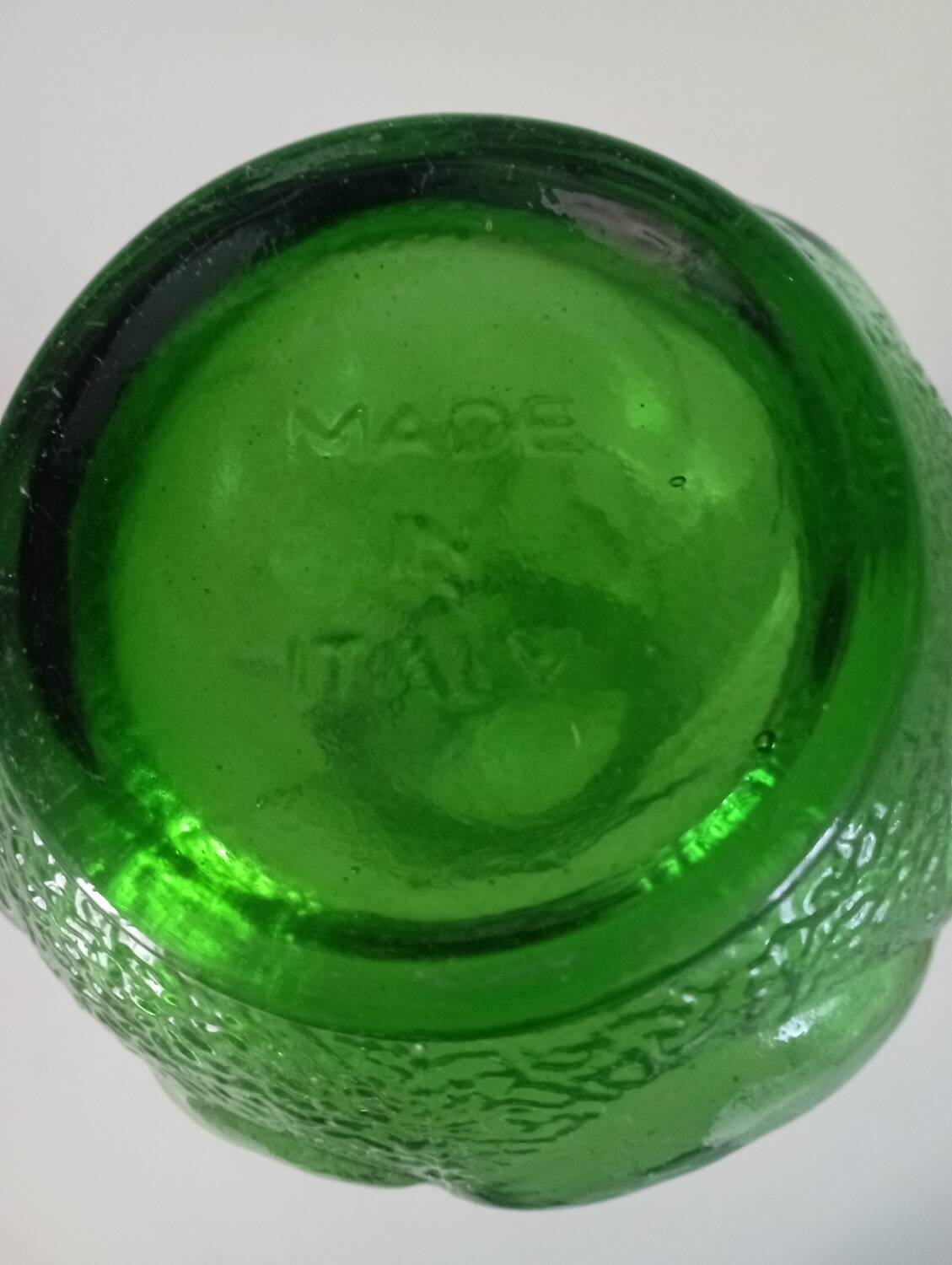 Green glass vase decorated with bunch of grapes and fruits