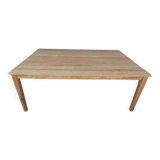 Large natural wood table with rectangular top supported by legs