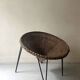 Italian basket chair in rattan and black metal, 1950s design.