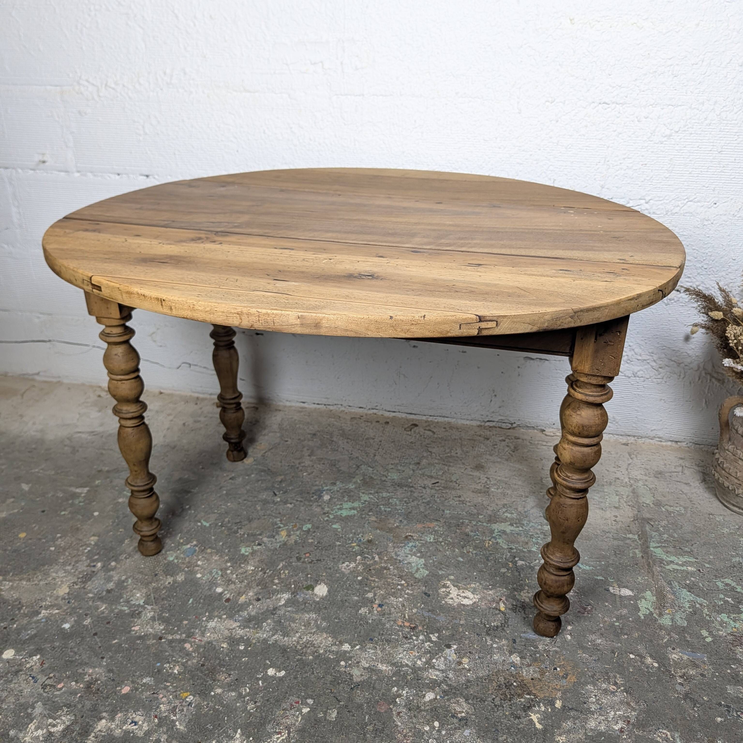 Antique wooden drop-leaf table with turned legs.