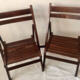 Pair of folding chairs in dark wooden slats