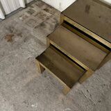 Trio of nesting tables, brass structures and smoked mirror tops