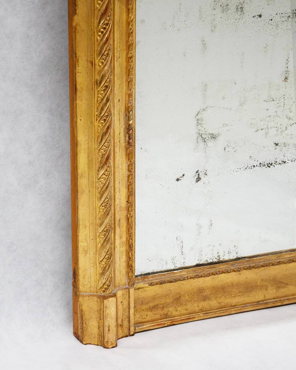 19th-century patinated mirror with a ribbon-style frame