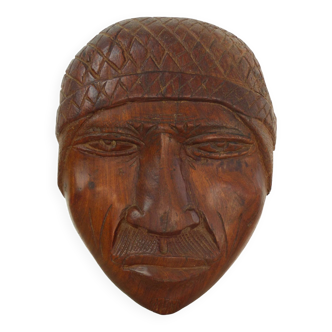Face sculpture in raw wood