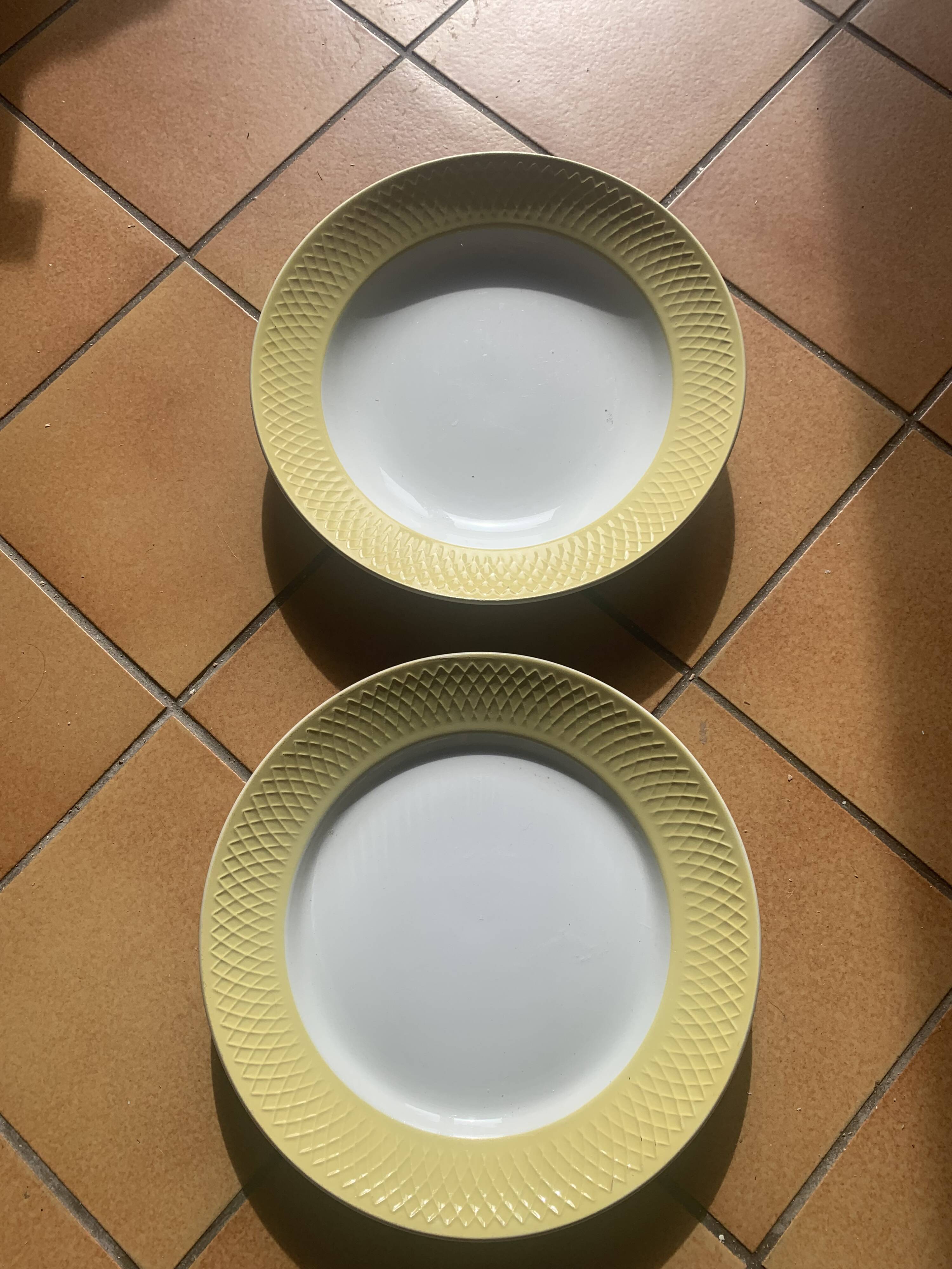 Two earthenware dishes, one hollow and one white cake dish with yellow border