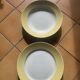 Two earthenware dishes, one hollow and one white cake dish with yellow border