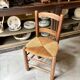 Provençal chair in dark wood and woven straw.