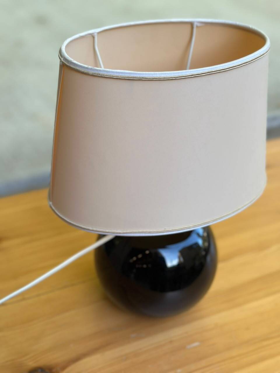 Vintage 80s table lamp with a black ceramic base and beige shade.