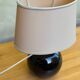 Vintage 80s table lamp with a black ceramic base and beige shade.