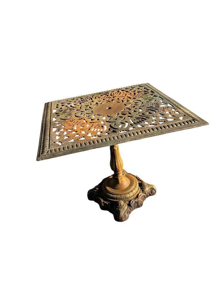 Antique cast iron garden table with decorative openwork top.
