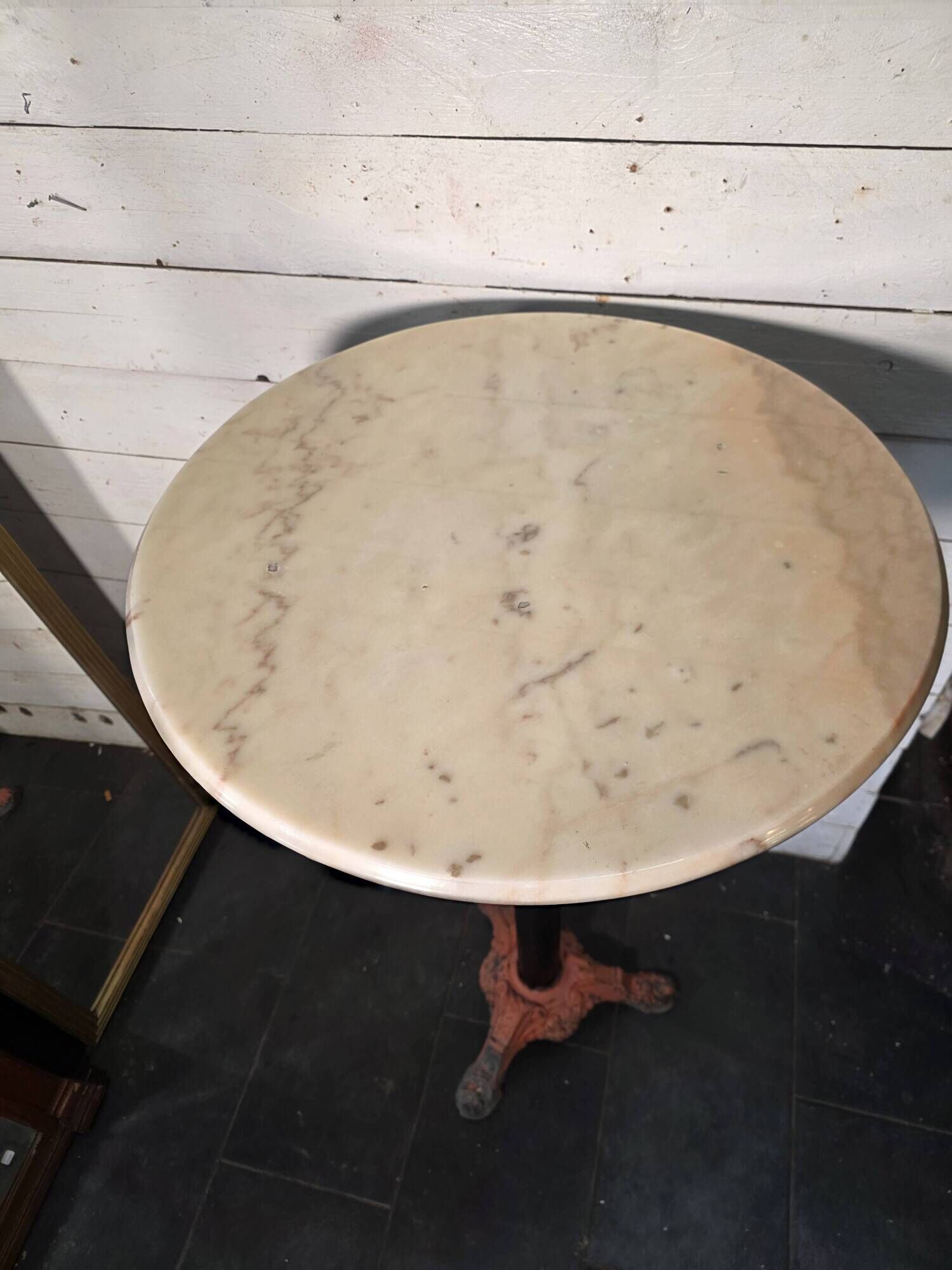 Bistro standing table with marble top and cast iron base.