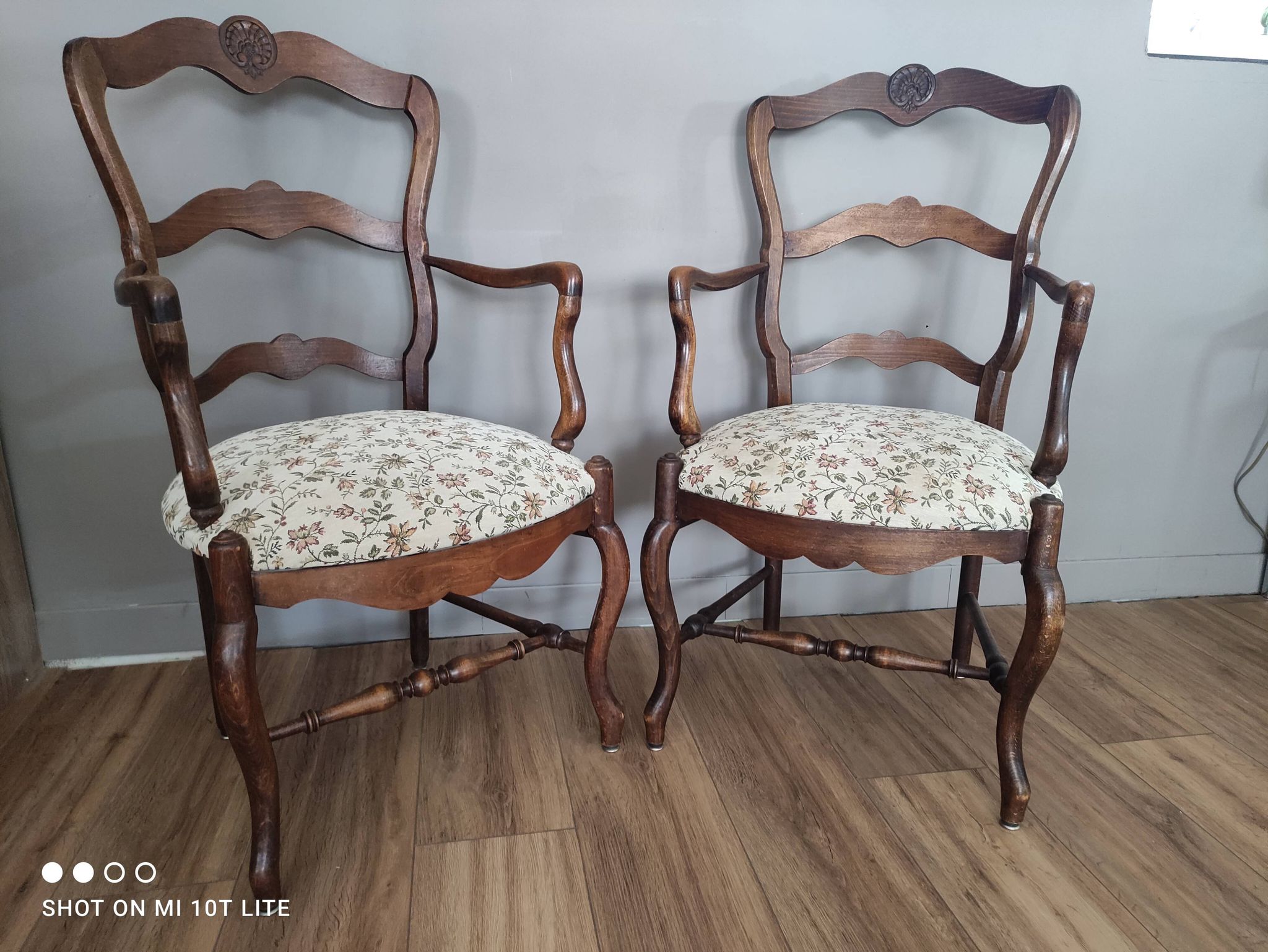 Pair of Provençal armchairs in brown wood and floral fabric.