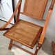 Pair of folding chairs in bamboo and caning, leather and brass