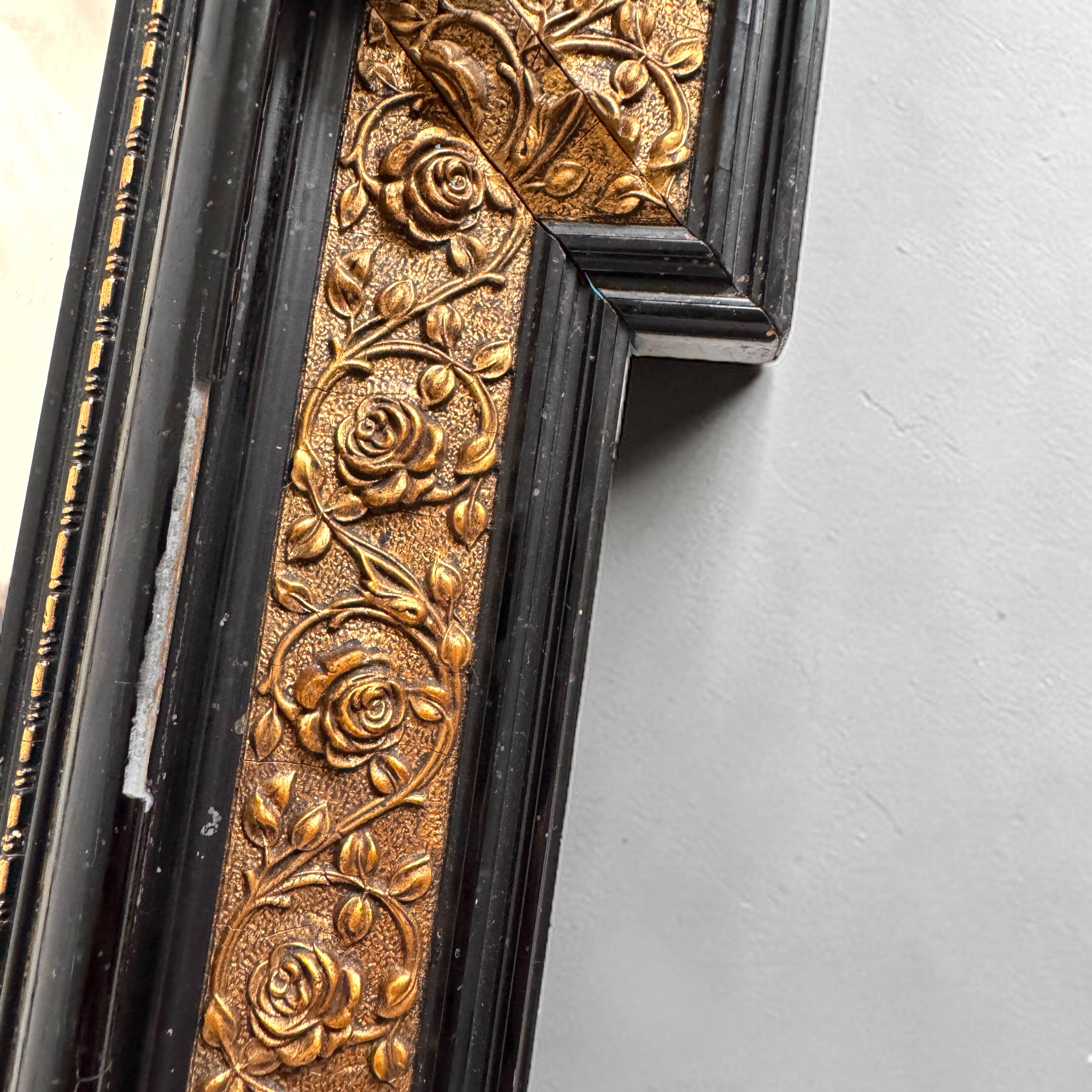 Antique wall mirror in blackened wood and gilded stucco, 19th-century Dutch style.