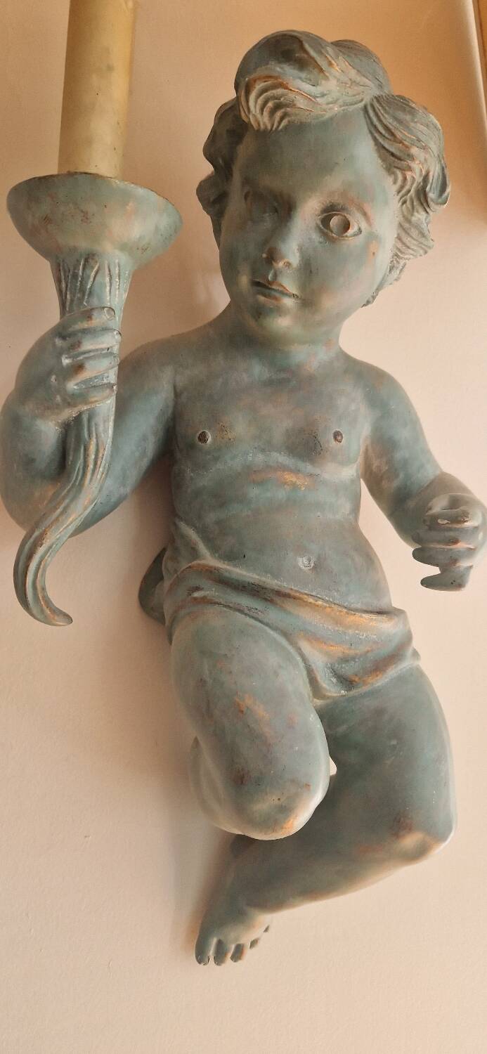 Pairs of wall lights, either two distinct cherubs.