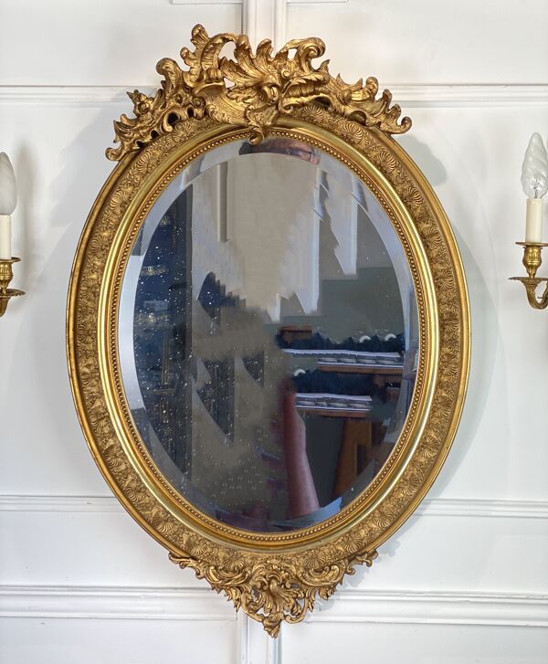 Miroir glace ovale époque Napoleon III en bois et stuc doré de style louis xv