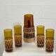 Vintage service for orangeade in amber glass and wicker.