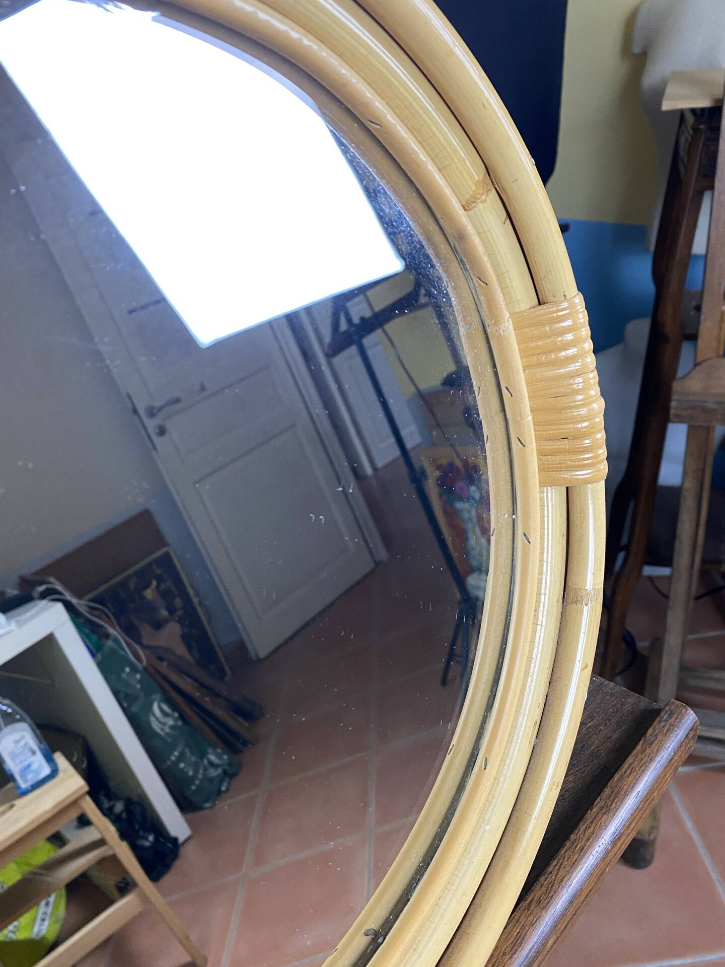 Round mirror from the 1960s with a frame made of rattan and metal.